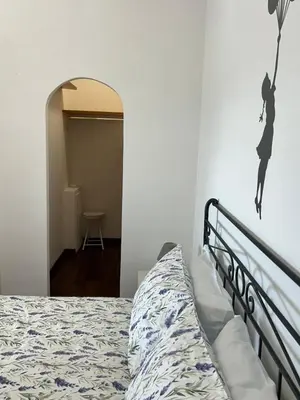a bedroom with a bed and a wall with a mirror at Green house - appartamento rome in Rome
