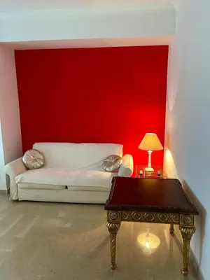 a room with a red wall and a couch and a table at Green house - appartamento rome in Rome