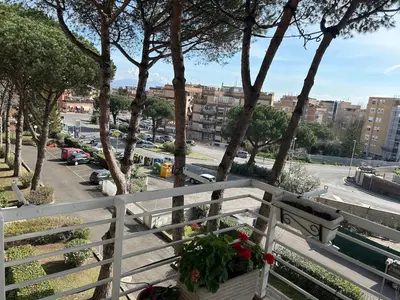 a white bench on a balcony with a view of a city at Green house - appartamento rome in Rome