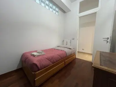 a bedroom with a bed in a white room at Green house - appartamento rome in Rome