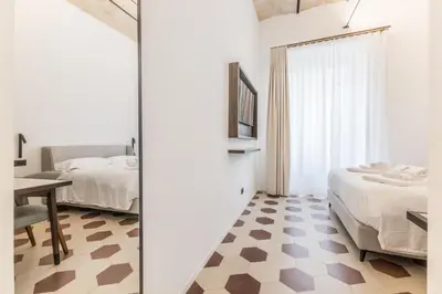 a bedroom with two beds and a table in a room at Domina Livia Vaticano Roma - Suite e Room in Rome