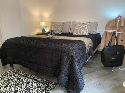 a bedroom with a bed with a black blanket and a suitcase at Domus Pacis in Rome
