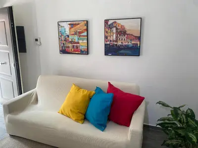 a white couch with four colorful pillows on it at Domus Pacis in Rome