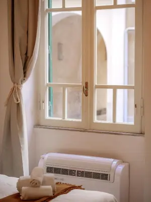 a bedroom with a window and a air conditioner at Labicana - Rome Apartment in Rome