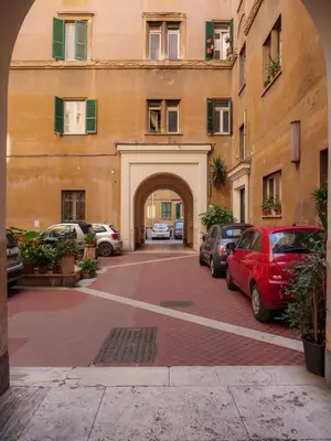 a large building with cars parked in a parking lot at Labicana - Rome Apartment in Rome