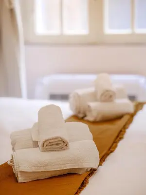 a pile of towels sitting on top of a bed at Labicana - Rome Apartment in Rome