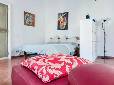 a bedroom with two beds and a red ottoman at Inn Pantheon Home in Rome