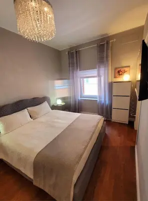 a bedroom with a large bed and a chandelier at Suite Benedict Pantheon in Rome