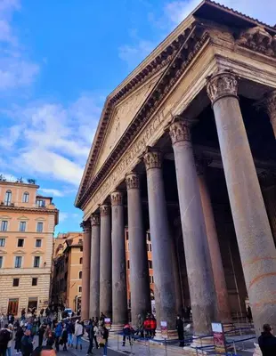a group of people walking in front of a building with columns at Suite Benedict Pantheon in Rome
