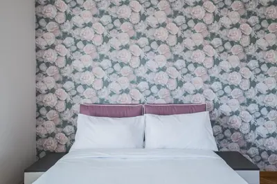 a bedroom with a bed with a floral wall at B&B Damagi in Rome