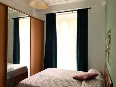 a bedroom with a bed and a mirror and a window at Casa Ferrari in Rome