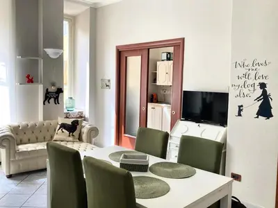 a living room with a table and green chairs at Casa Ferrari in Rome