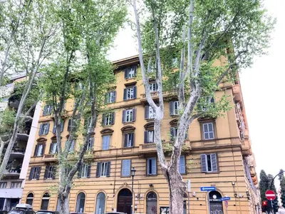 a yellow building with trees in front of it at Casa Ferrari in Rome