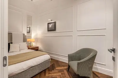 a bedroom with a bed and a chair at Piazza Venezia Luxe Apartment in Rome