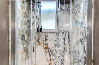 a bathroom with a shower with a mirror and a window at Piazza Venezia Luxe Apartment in Rome