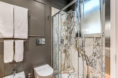 a bathroom with a shower and a toilet at Piazza Venezia Luxe Apartment in Rome