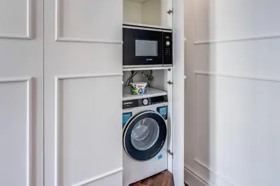 a kitchen with a microwave and a washing machine at Piazza Venezia Luxe Apartment in Rome