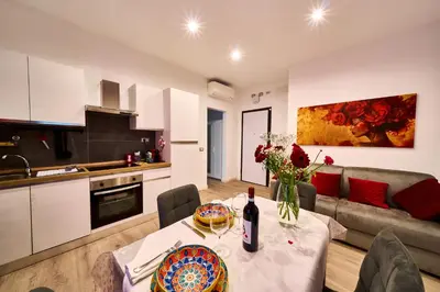 a kitchen and a living room with a table with flowers at Vatican Meadows Apartment in Rome
