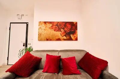a living room with a couch with red pillows at Vatican Meadows Apartment in Rome