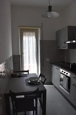 a kitchen with a table and a table and a window at Casa Vacanza SADAMA in Rome