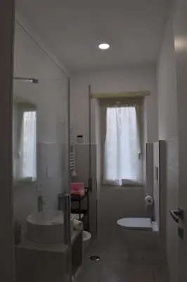 a white bathroom with a sink and a toilet at Casa Vacanza SADAMA in Rome