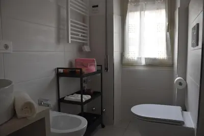 a white bathroom with a toilet and a sink at Casa Vacanza SADAMA in Rome