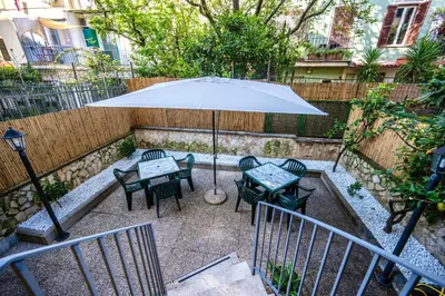 a patio with an umbrella and a table and chairs at Exquilia Home & Garden at the Colosseum in Rome