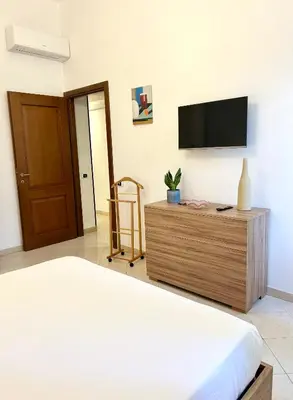 a bedroom with a bed and a flat screen tv at Exquilia Home & Garden at the Colosseum in Rome