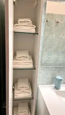 a bathroom with white towels on shelves in a shower at Exquilia Home & Garden at the Colosseum in Rome