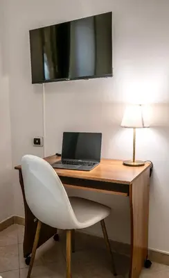 a desk with a laptop and a white chair at Exquilia Home & Garden at the Colosseum in Rome