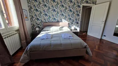 a bedroom with a bed with a blue and white wallpaper at Re di Roma vacation in Rome