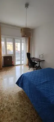 a bedroom with a blue bed and a table at Casa con Lorenzo in Rome