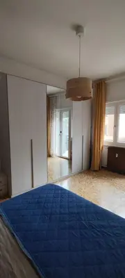 a bedroom with a blue bed in a room with windows at Casa con Lorenzo in Rome