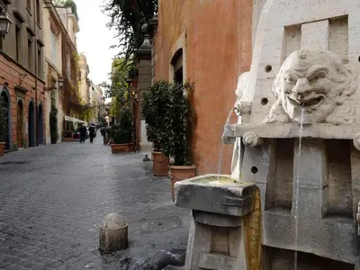 a water fountain with a lion on the side of a building at Margutta 54 Luxury Suites in Rome