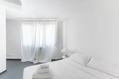 a white bedroom with a bed and a window at Balduina Home in Rome