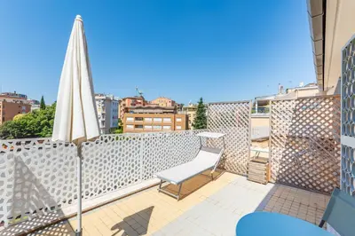 a balcony with a chair and a white umbrella at Balduina Home in Rome