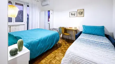 a bedroom with two beds and a desk and a table with a chair at 3 Passi Da Metro Marconi- 8 min Colosseo in Rome