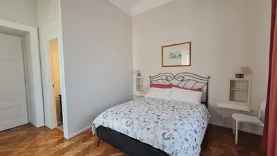 a white bedroom with a bed with a red headboard at Jolegrè all'Opera in Rome