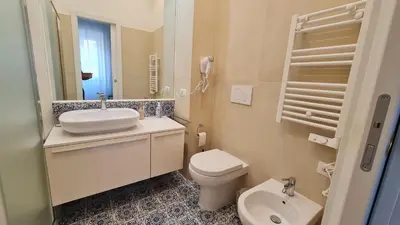 a white bathroom with a sink and a toilet at Jolegrè all'Opera in Rome