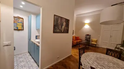 a kitchen and a living room with a table at Jolegrè all'Opera in Rome