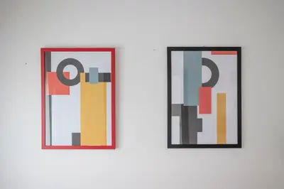 two pieces of art on a white wall at Attic Candia - Vatican Museum in Rome