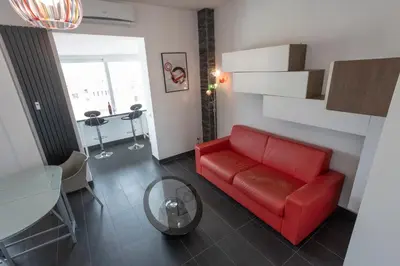 a living room with a red couch and a table at Attic Candia - Vatican Museum in Rome