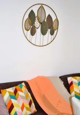 a couch with colorful pillows and a clock on the wall at Sophia Luxury Home confortevole e in ottima posizione in Rome