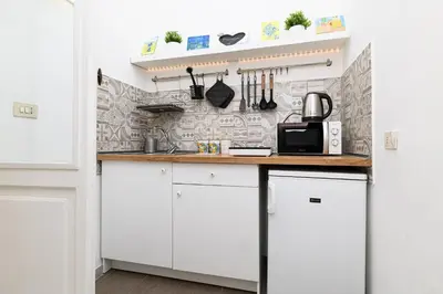 a kitchen with white cabinets and a counter with a microwave at La Casina di Luigi con balcone in Rome