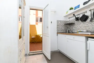 a kitchen with white cabinets and a door leading to a patio at La Casina di Luigi con balcone in Rome