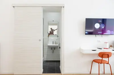 a bathroom with a white door and a mirror at Bottega Artistica Guest House in Rome