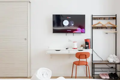 a room with a desk and a chair and a tv on the wall at Bottega Artistica Guest House in Rome