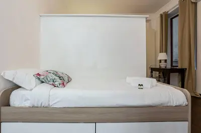 a bed with white sheets and a pillow on it at Fontana di Trevi a 2 passi in Rome