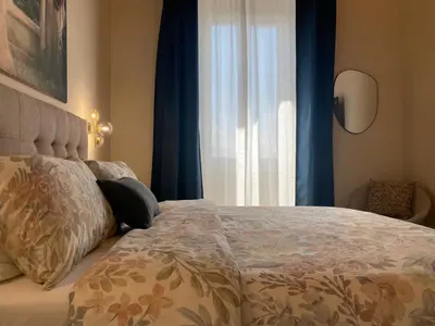 a bedroom with a bed with blue curtains and a window at Talamo Heritage in Rome