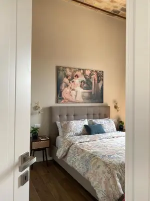 a bedroom with a bed with a painting above it at Talamo Heritage in Rome